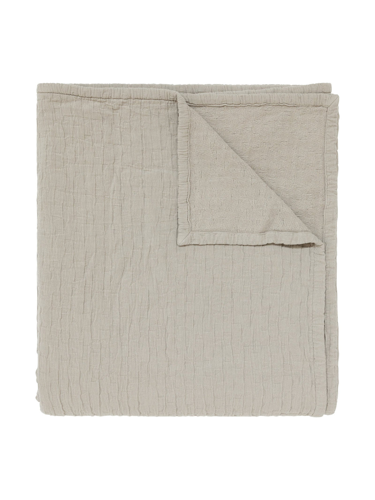 A folded light beige textured muslin blanket 