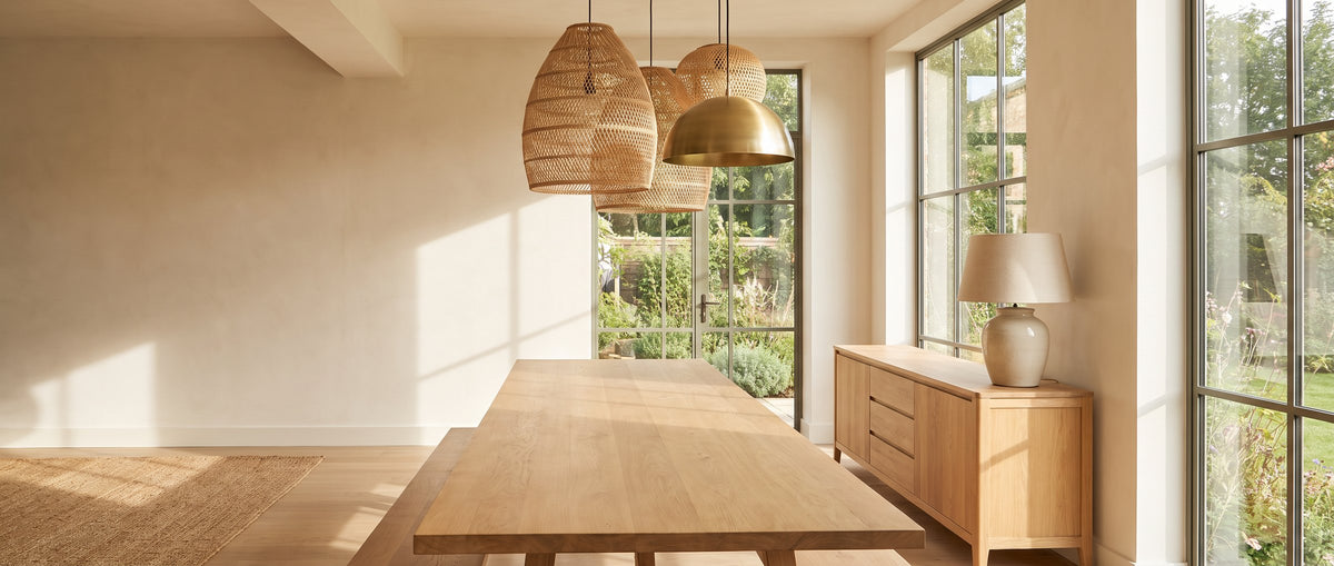 Rattan and brass pendant lights above an oak dining table